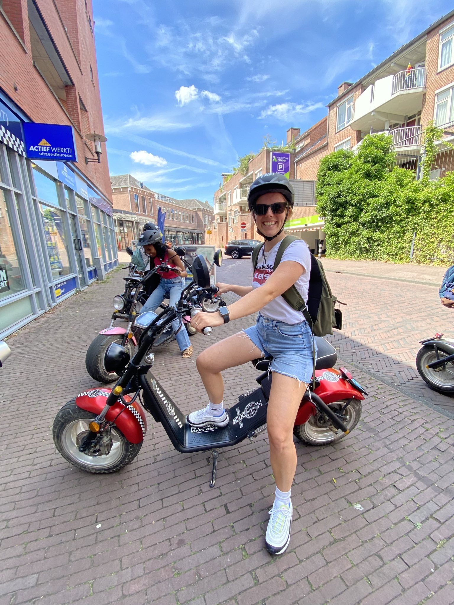 Foto van Aniek op scooter met helm en zonnebril op