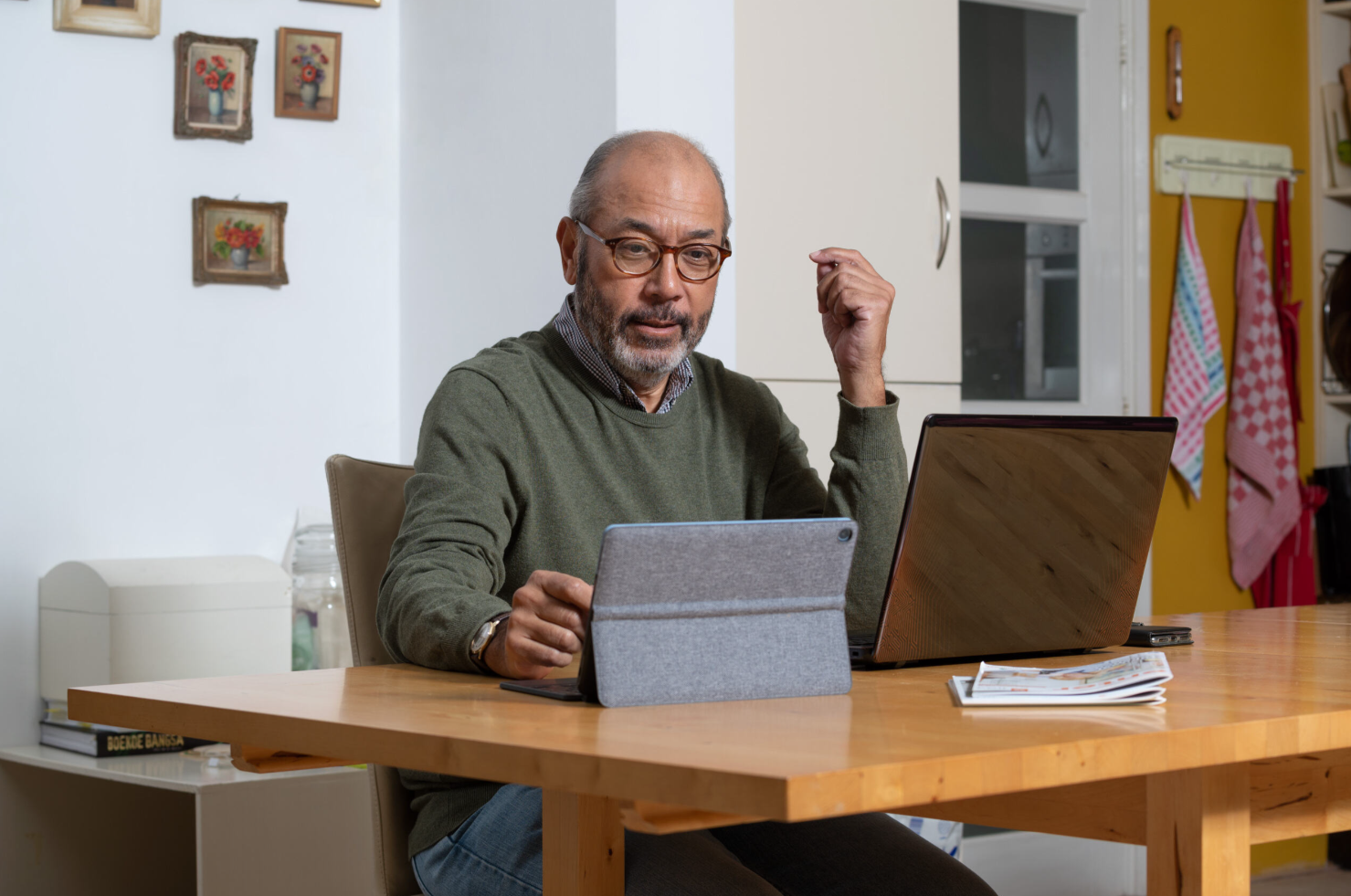 Man zit achter computer en tablet.